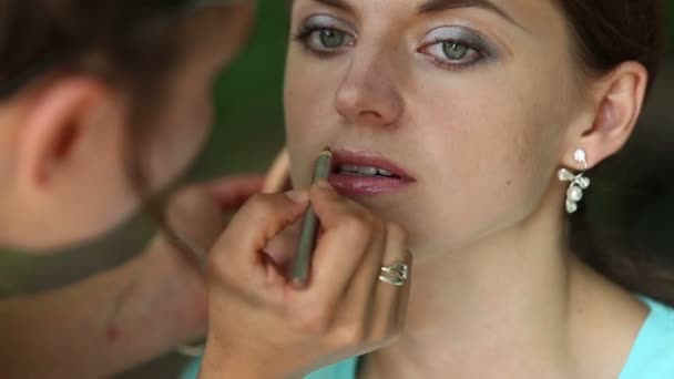 Стилист наносит макияж на лицо — стоковое видео