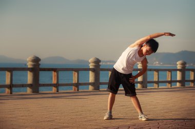 vietnamese boy does bending aside on embankment at dawn