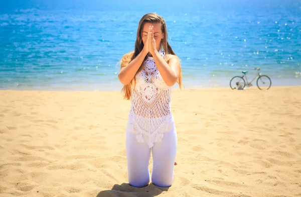 Meisje praktizerende yoga op het strand Stockfoto