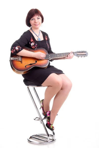 Brunette girl in black dress play guitar — Stock Photo, Image