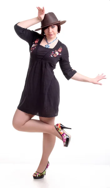 Brunette girl poses in black dress and hat — Stock Photo, Image