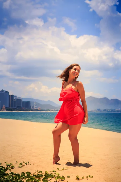 Blond tjej i röd dansar barfota på sand vind skakar långt hår — Stockfoto