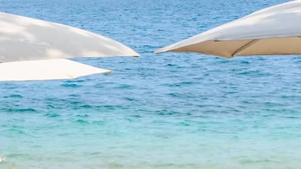 Белый зонтик над лазурным морем — стоковое видео