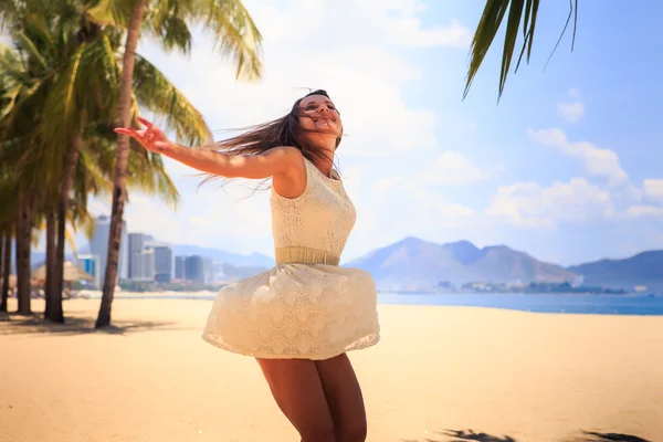 Menina magro na vista traseira branca poses com as mãos para cima na praia — Fotografia de Stock