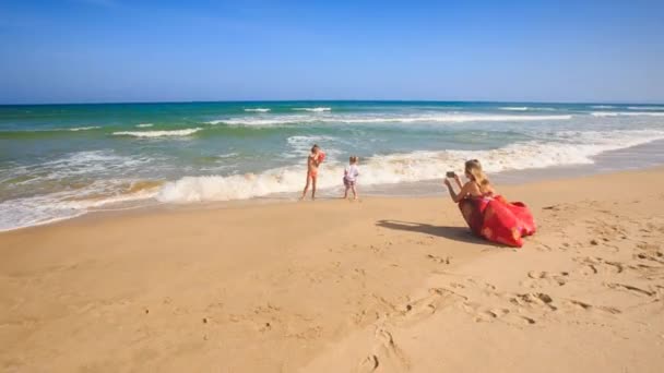 Moeder en kinderen op het strand — Stockvideo