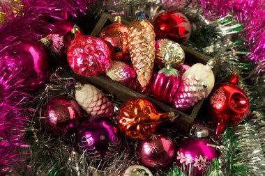 SSCB zamanından kalma kozalak ve kar taneleri şeklinde eski yılbaşı oyuncakları. Noel ağacında pembe, kırmızı ve kırmızı oyuncaklar ve ahşap bir kutuda gümüş süslemeler.