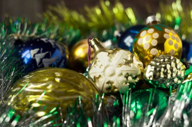 SSCB zamanından kalma eski yılbaşı oyuncakları kar taneleri, koniler ve diğer figürler şeklinde. Ahşap bir kutuda Noel ağacı için pembe, mavi ve altın oyuncaklar. Arkaplan