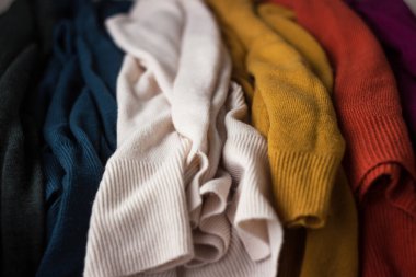 Birçok örgü kadın kazağı arka arkaya yalan söyler. Parlak çok renkli (sarı, beyaz, turuncu ve diğerleri) kazaklar dağınık bir vaziyettedir. Rahatlık