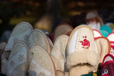 Dışarıdaki deriden yapılmış, içinde yün olan terlikler, market. Carpathian ayakkabıları
