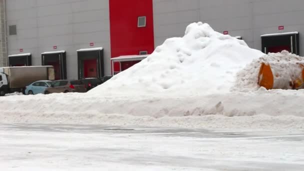 Τρακτέρ καθαρίζει χιόνι στο έδαφος των αποθηκών — Αρχείο Βίντεο