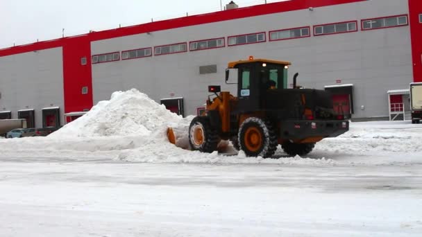 Трактор чистит снег на территории складов — стоковое видео