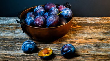 İtalyan erikleri kırsal görünümlü kase ve ahşap masa.