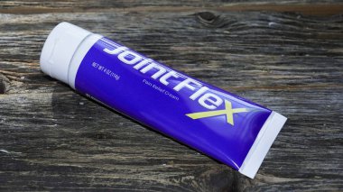 NORWALK, CT, USA- OCTOBER 10, 2025: A tube of pain relief cream sits on a rustic wooden surface, showcasing its bright packaging. This topical solution targets joint discomfort and promotes relief.