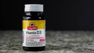 NORWALK, CT, ABD - 30 Ekim 2025: 50 mcg ve 100 softgel içeren bir şişe D3 vitamini bir tezgahın üzerine yerleştirilir. Kemiği ve bağışıklık sistemini desteklemek için tasarlandı. Bu da onu hayati bir beslenme takviyesi yapıyor..