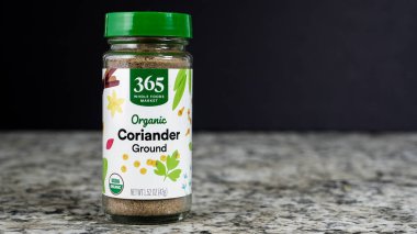 NORWALK, CT, ABD - 30 Ekim 2025: Bir kavanoz organik zemin kişniş granit tezgahta belirgin bir şekilde bulunur. Ayar bir anı yakalıyor, mutfak hazırlığı ve malzemelerini gösteriyor..