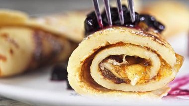 Eating freshly made crepes filled wild huckleberry spread and orange marmalade. Great  experience of tasting these treats.