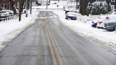 NORWALK, CT, USA- 27 Aralık 2025: kar yolu kaplıyor bir kış fırtınası geçerken. Evler her iki taraftan da görülebiliyor, arabalar cadde boyunca park halinde. Elektrik hatları tepemizde akıyor..