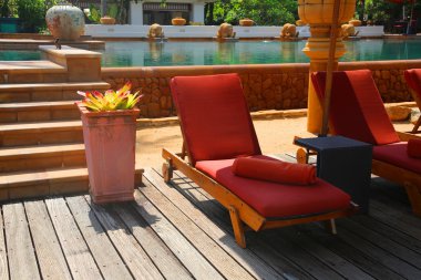 The vacation place in the hotel next to the pool in a shade and pool towel, in Phuket, the tropic island, Thailand, Asia