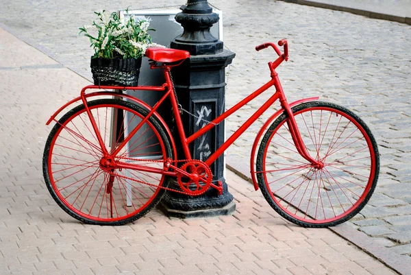 Fahrrad mit dem Korb voller Farben an einem Pfosten — Stockfoto