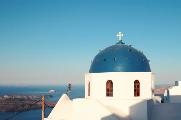 Санторини с церковью, архитектурой и морем — стоковое фото