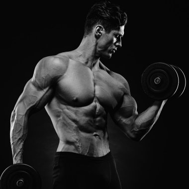 Yakışıklı atletik adam kaslarını şişiriyor.