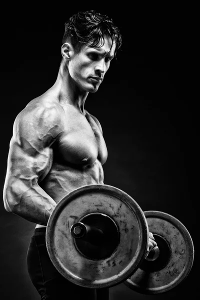 Nahaufnahme Porträt eines muskulösen Mannes beim Training mit der Langhantel im Fitnessstudio. — Stockfoto