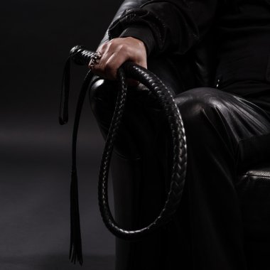 male hand holding black leather whip clipart