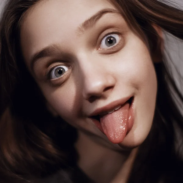 Молодая женщина, показывающая свой язык — стоковое фото