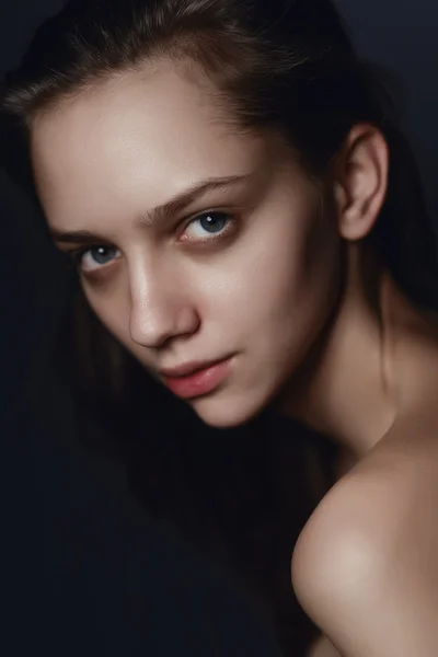 Porträt einer schönen jungen brünetten Frau im Studio auf einem — Stockfoto