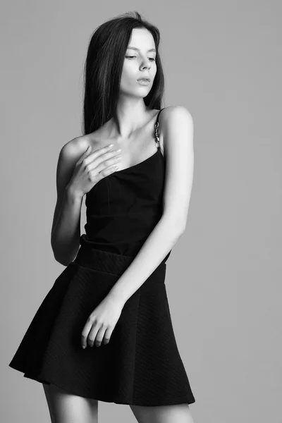 Beautiful young model in elegant black dress posing in the studi — Stock Photo, Image