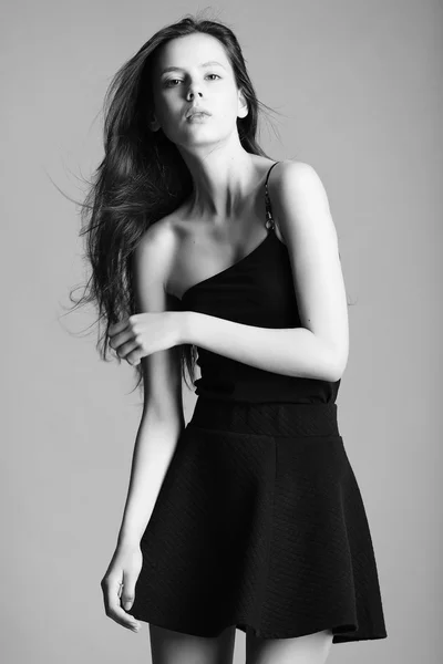 Piękny model młody w eleganckiej czarnej sukni pozowanie w studi — Zdjęcie stockowe