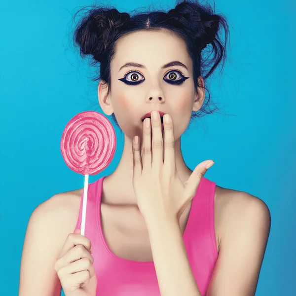 Hermosa chica con una piruleta y una camisa de color rosa brillante —  Fotos de Stock