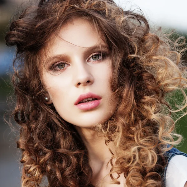 Uzun kıvırcık saçlı güzel bir genç kız portresi — Stok fotoğraf