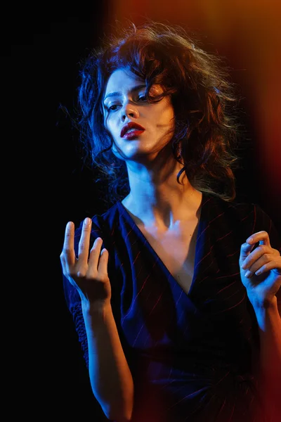 Beautiful brunette in the glow of blue and red light — Stock Photo, Image