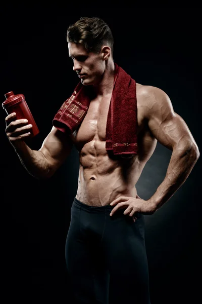 Muscular fitness masculino fisiculturista segurando proteína shake garrafa — Fotografia de Stock