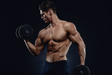 Yakışıklı atletik adam kaslarını şişiriyor.