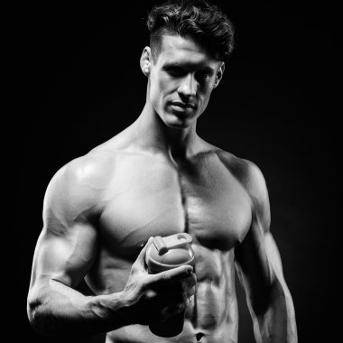 Adam gri arka plan üzerinde poz adam vücut geliştirmeci bir shake tutuyor