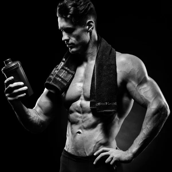 Muskulöse Fitness männliche Bodybuilder mit Protein-Shake-Flasche — Stockfoto