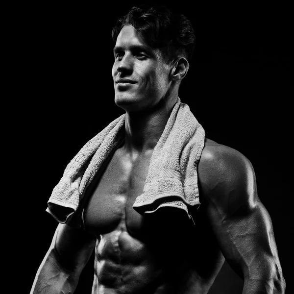 Sano muscolare giovane uomo dopo un allenamento su sfondo scuro . — Foto Stock