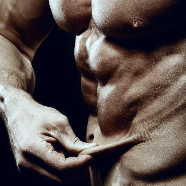 Bodybuilder visar en brist på fett på magen. — Stockfoto