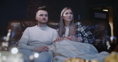 Genç bir çift akşamları TV 'de korku filmi izliyor, geceleri oturma odasında korku videosu seyrediyor. Hem kız hem de erkek korkarlar, korkarlar ve gülerler.