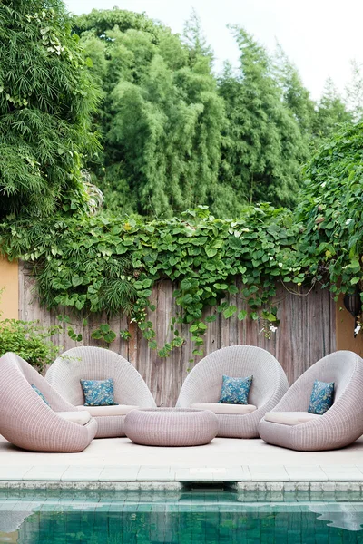 Relaxing chairs with pillows beside swimming pool — Stock Photo, Image