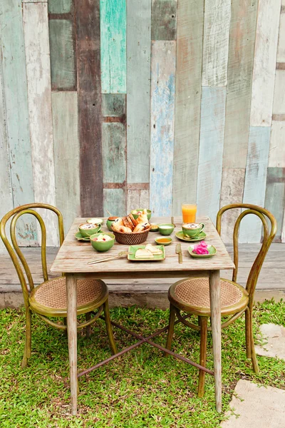 Desayuno en el jardín con café y una comida sencilla. Buen humor para todo el día . — Foto de Stock