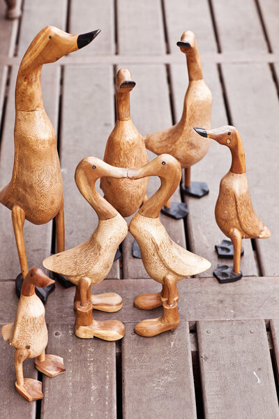 Seven hand made wooden ducks on wood background