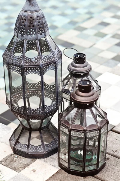 Vintage candle lamps standing near swimming pool. Summer in wint