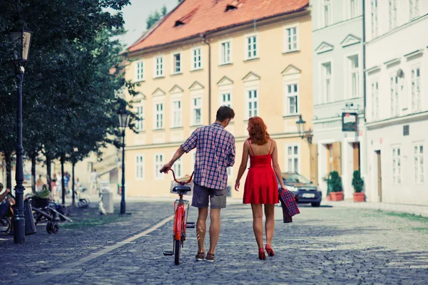 Par går på gatan med cykel. — Stockfoto