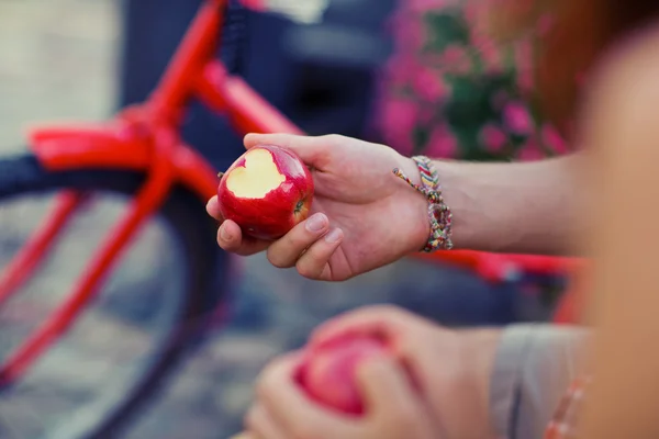 Pareja feliz con una manzana al aire libre. Manzana roja con corazón grabado —  Fotos de Stock