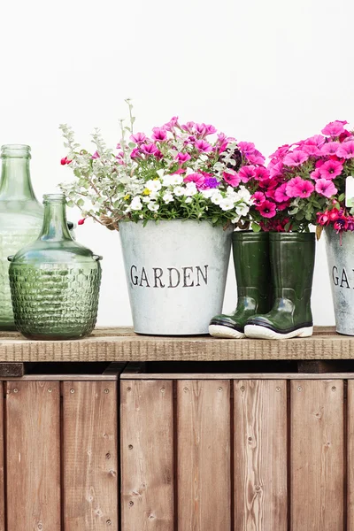 Flores en un cubo, botellas de vidrio vintage sobre fondo de madera , — Foto de Stock