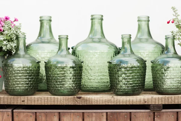 Flores en un cubo, botellas de vidrio vintage sobre fondo de madera , —  Fotos de Stock