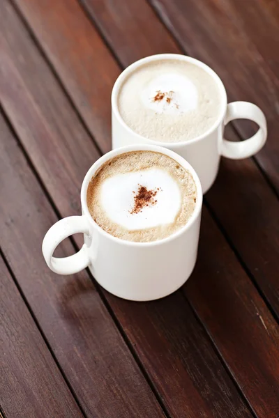 Šálek kávy Cappuccino na dřevěný stůl. — Stock fotografie